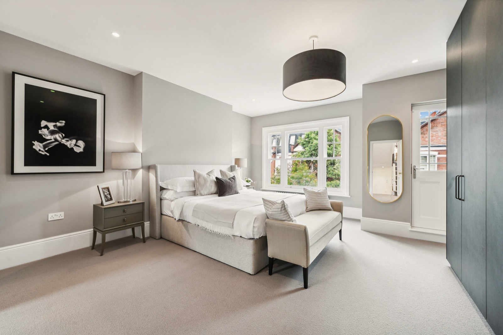 A bedroom with fitted wardrobes and sash windows