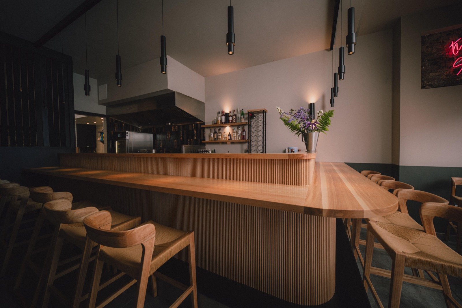 The rounded end of the counter and its reeded front, the kitchen canopy behind